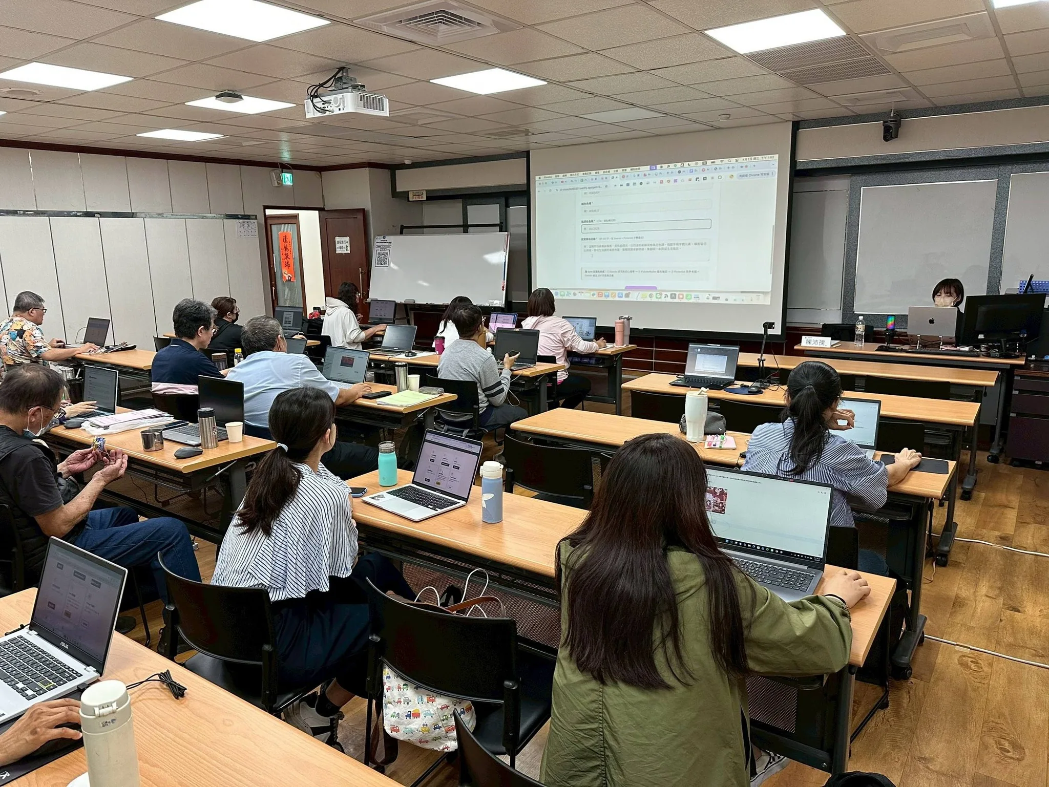 Penny 在教室帶領 AI 實作課，學員使用筆電同步操作